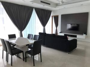 a living room with a couch and a table and chairs at Lovely 3 Rooms with KLCC View, Pavilion & Netflix in Kuala Lumpur