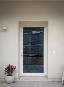 een glazen deur met een vaas met bloemen ervoor bij Casa di Marina, tra Etna e mare. in Gravina di Catania