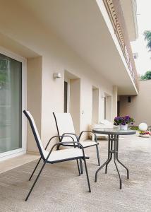 two chairs and a table on a patio at Casa di Marina, tra Etna e mare. in Gravina di Catania