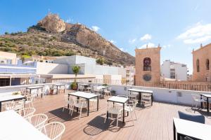 a rooftop patio with tables and chairs on a building at VIL5 by Be Alicante in Alicante