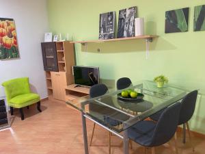 a dining room with a glass table and chairs at Apartamentos Alcañiz, Alicia in Alcañiz