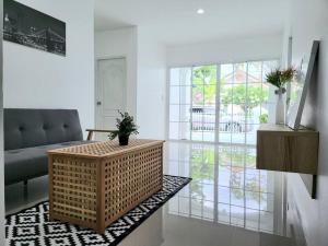 a living room with a wicker table and a couch at Minimal homey 3BR near Mee Chok plaza in Chiang Mai