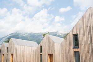 a group of wooden buildings with mountains in the background at Cabino - Fresh Air Resort in Bovec