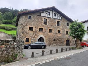 a car parked in front of a stone building at Casa Rural Goikitxe Etxea in Goizueta