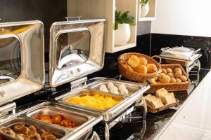 a counter with trays of food and baskets of bread at INNSiDE by Meliá Leipzig in Leipzig