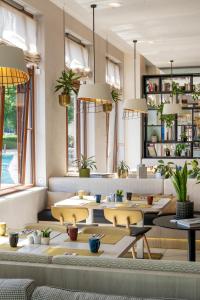 a restaurant with tables and chairs and windows at INNSiDE by Meliá Leipzig in Leipzig