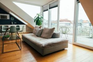 ein Wohnzimmer mit einem Sofa und einem großen Fenster in der Unterkunft Large Apartments - Great for Groups - with Balcony or Terrace in Wien