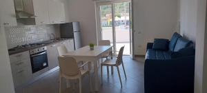 uma cozinha e sala de estar com uma mesa e um sofá em Tenuta Nonna Peppa Luxury apartment em Palinuro