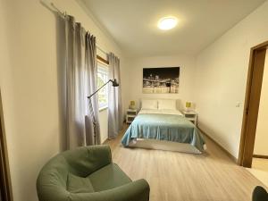コスタ・ダ・カパリカにあるCaparica's Beach Apartment by Trip2Portugalのベッドルーム1室(ベッド1台、椅子付)