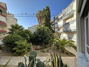 コスタ・ダ・カパリカにあるCaparica's Beach Apartment by Trip2Portugalの建物のバルコニーから庭園の景色を望めます。