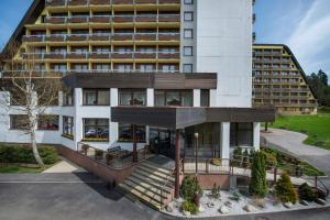an apartment building with a porch in front of it at Hotel SOREA ĽUBOVŇA in Stará Ľubovňa
