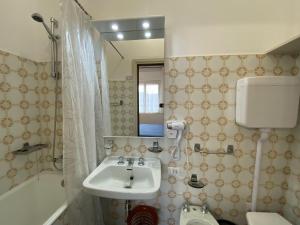 a bathroom with a sink and a toilet and a tub at Albergo Lodrino in Villa