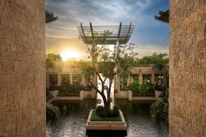 een gebouw met een boom in het midden van een binnenplaats bij Banyan Tree Mayakoba in Playa del Carmen