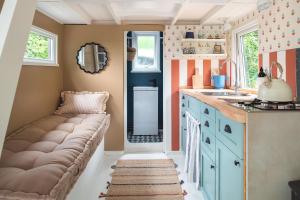 uma cozinha com um sofá num pequeno quarto em Fleur de Grog - Shepherds Hut em Bodmin