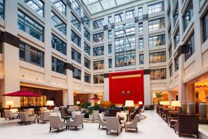 a lobby with tables and chairs and a large building at Wyndham Grand Xi'an Residence in Xi'an