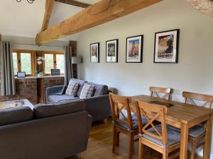 a living room with a table and a couch at Two bed barn in Henley in Arden