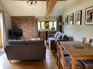 a living room with a couch and a table at Two bed barn in Henley in Arden