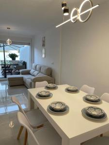 a living room with a table with plates on it at Adosado Vinaròs in Vinarós