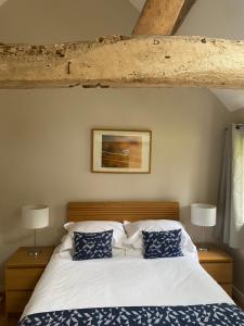 a bedroom with a bed with blue and white pillows at Two bed barn in Henley in Arden