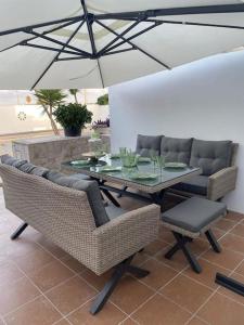 una mesa con sillas y una sombrilla en el patio en Adosado Vinaròs en Vinarós