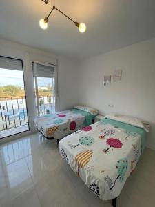 two beds in a room with a view of the ocean at Adosado Vinaròs in Vinarós