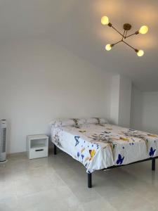 a bed in a room with a white wall at Adosado Vinaròs in Vinarós +17 photos