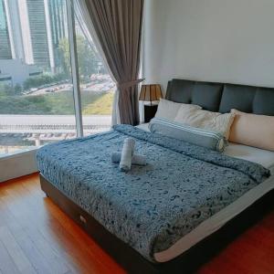 una cama con un osito de peluche sentado encima en 3 Guests,200m to KLCC & Pavilion Mall with Netflix en Kuala Lumpur