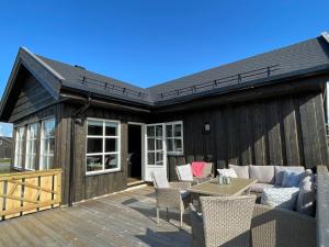 une terrasse en bois avec un canapé et des chaises. dans l'établissement Tisleibu - cabin at Golfjellet, à Tisleidalen