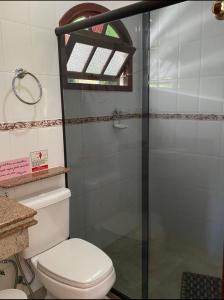 a bathroom with a toilet and a glass shower at Casa Mara in Nova Friburgo