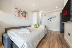 een slaapkamer met een groot wit bed in een kamer bij 3 West London Brand New Loft in Londen