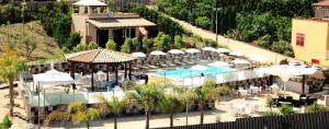 een luchtzicht op een resort met een zwembad, tafels en parasols bij Hotel Costazzurra Museum & Spa in San Leone