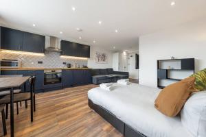 倫敦的住宿－3 West London Brand New Loft，厨房以及带床和桌子的客厅。