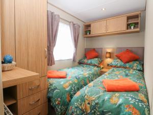 ein kleines Schlafzimmer mit 2 Betten und einem Schreibtisch in der Unterkunft Stanley's Lodge, Foxburrow Hang in Great Yarmouth