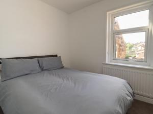 a white bed in a room with a window at 3 Glendowne Terrace in Harrogate