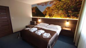 a hotel room with a bed with towels on it at Hotel SOREA ĽUBOVŇA in Stará Ľubovňa +37 photos