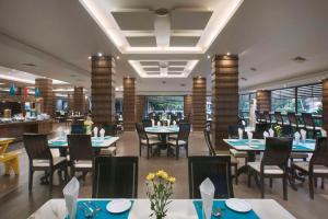 a dining room with tables and chairs in a restaurant at Radisson Blu Resort, Goa in Cavelossim