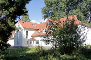 a white house with an orange roof at Haus Müritz, FeWo 11 Fischadler in Zielow