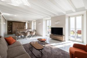 a living room with a couch and a tv and a table at Maison MUSA at Vita B in Lenno