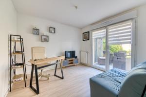 ein Wohnzimmer mit einem Tisch und einem Schreibtisch in der Unterkunft Le St Gratien - Appartement avec jardin in Épinay-sur-Seine
