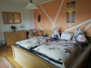 Un dormitorio con una cama con flores. en Gästehaus Reisacher - Mehrbettzimmer, en Peiting
