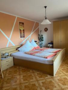 1 dormitorio con 1 cama grande en una habitación en Gästehaus Reisacher - Mehrbettzimmer, en Peiting