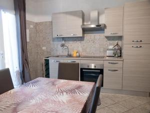 uma cozinha com uma mesa, um lavatório e um fogão em Trilocale vicino al mare em Piombino