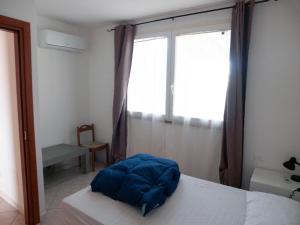 um quarto com uma cama e uma janela grande em Trilocale vicino al mare em Piombino