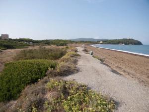 a dirt road next to a beach next to the water at Trilocale vicino al mare in Piombino
