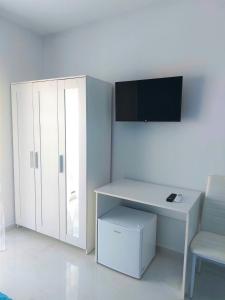 アグローポリにあるVilla Milena Apartments & Roomsの白いデスクと白いキャビネットが備わる客室です。