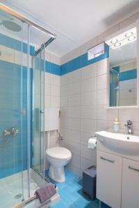 a bathroom with a toilet and a glass shower at Blue Breeze in Milatos