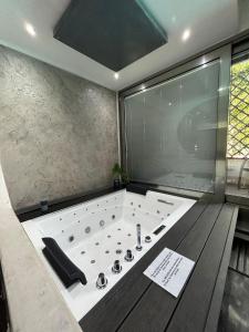 a bathroom with a large bath tub with a window at Residence Villa Rosa dei Venti in Cinisi