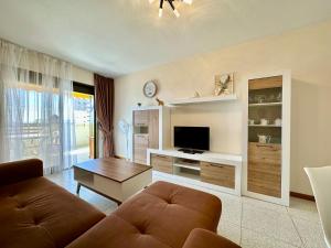 ein Wohnzimmer mit einem Sofa und einem TV in der Unterkunft Edf Calpe Place, planta 7 - primera linea in Calpe