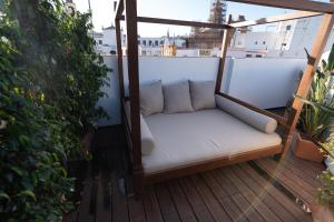 eine Veranda mit einem weißen Sofa auf dem Balkon in der Unterkunft The Terrace, dúplex con terraza privada in Sevilla