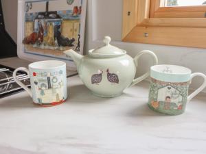 três chávenas de café e um bule de chá no balcão em Shepherds Hut em Scunthorpe